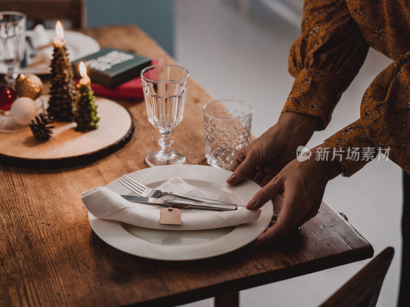 女人在布置圣诞餐桌，准备晚宴