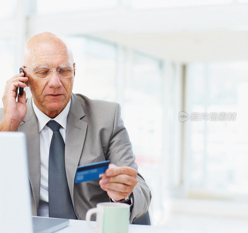 一个上了年纪的商人用信用卡在网上购物