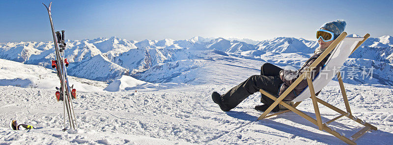 一个女孩在一个滑雪场附近的躺椅上晒日光浴