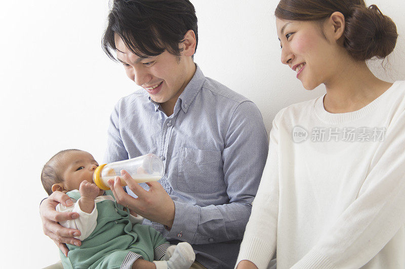 一对日本夫妇用奶瓶给婴儿喂奶