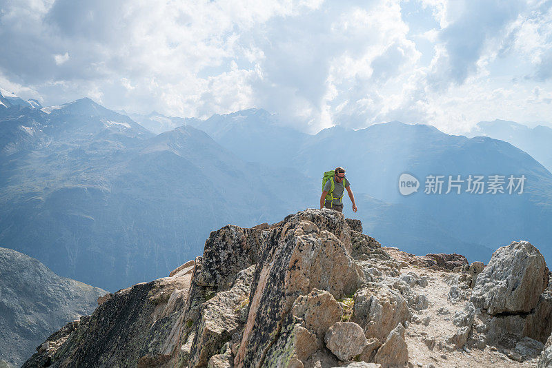 年轻人攀登山道上的岩石，以达到顶峰;人们户外活动概念拍摄于瑞士