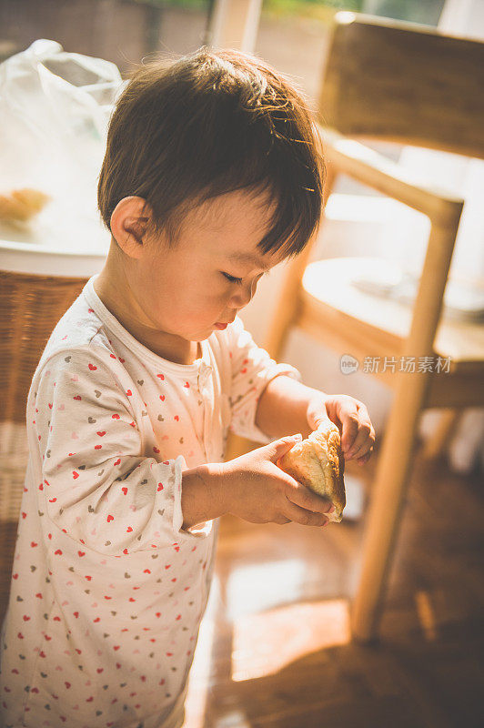 一个亚洲小女孩吃面包