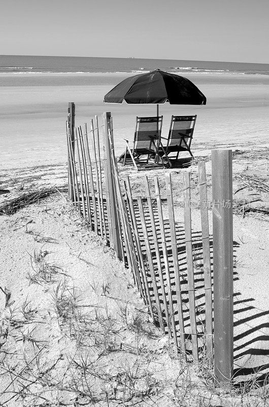 海滩伞和椅子在大西洋前拍摄的黑白照片
