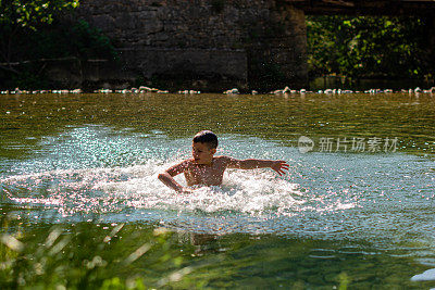 孩子在水中嬉戏，溅起水花。