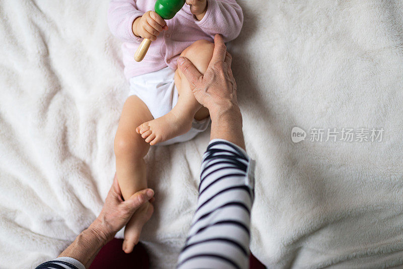 小婴儿接受骨科治疗她的腿，以防止髋关节发育不良的儿科理疗师