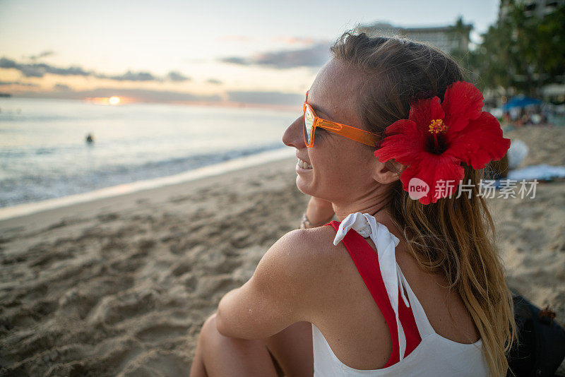 年轻女子在夏威夷威基基海滩上凝视日落