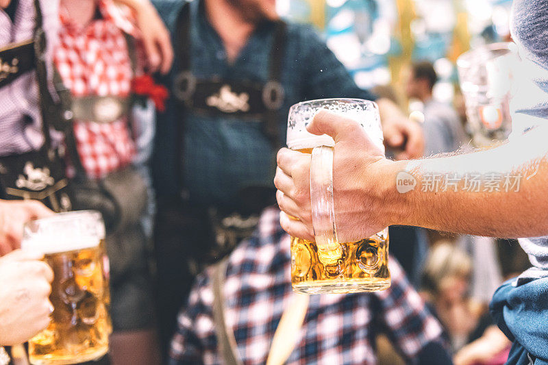慕尼黑啤酒节上，手持啤酒杯的男性