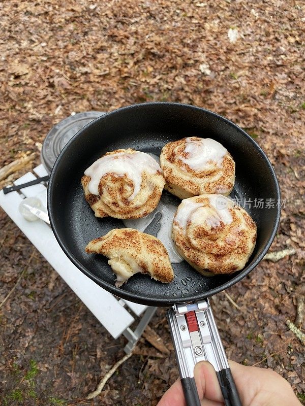 在野营炉上放肉桂卷和糖霜