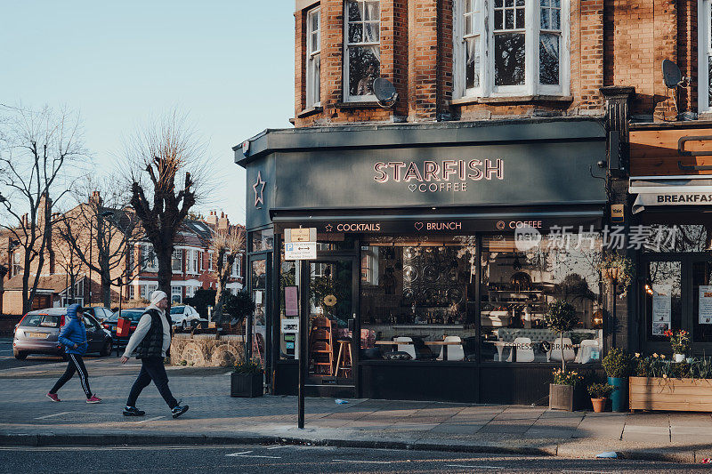 英国伦敦帕尔默斯格林的海星咖啡馆关闭，人们走过，运动模糊。