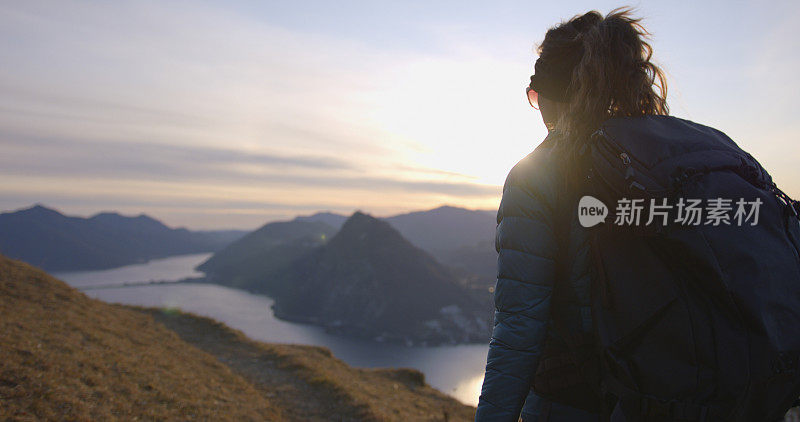 女性徒步旅行者在湖泊和欧洲阿尔卑斯山上行走