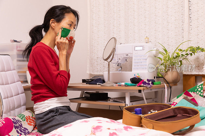 一名日本妇女在家里制作面具