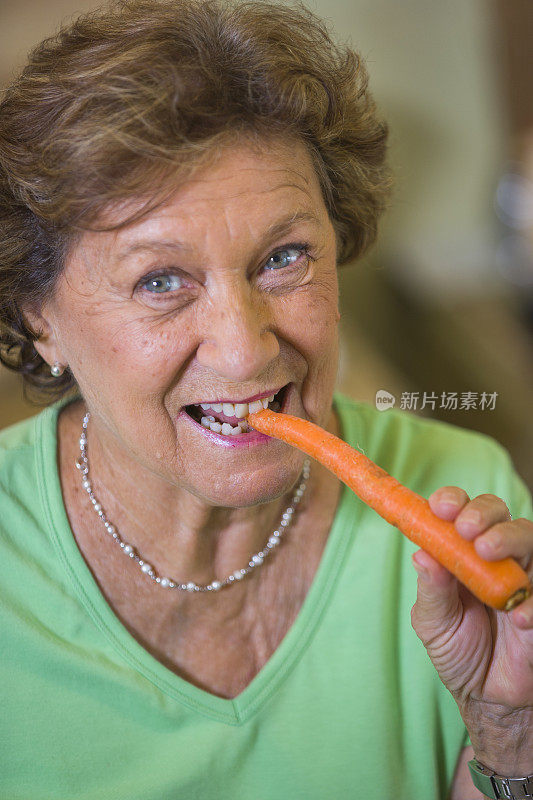 成熟的女人在家里吃胡萝卜