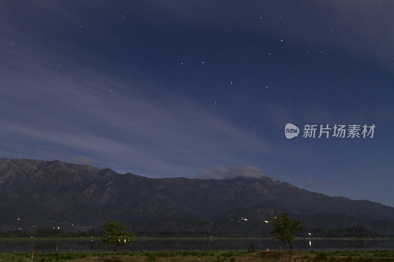 美丽的巴塔哥尼亚风景安第斯山脉与高山与发光的山峰，石头在山湖，反射，蓝色的天空与夜晚开始。