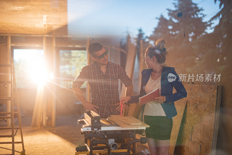 女建筑承建商在建筑工地向工人发出指示。