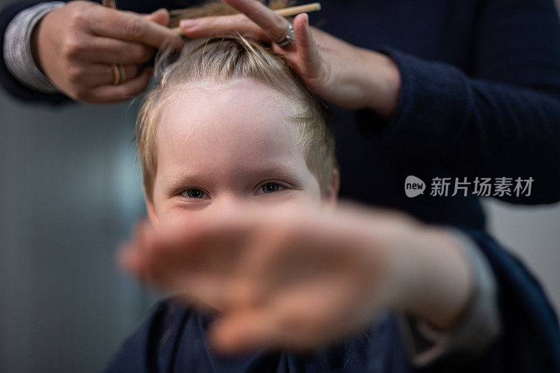 一个十几岁的金发男孩在家里理发