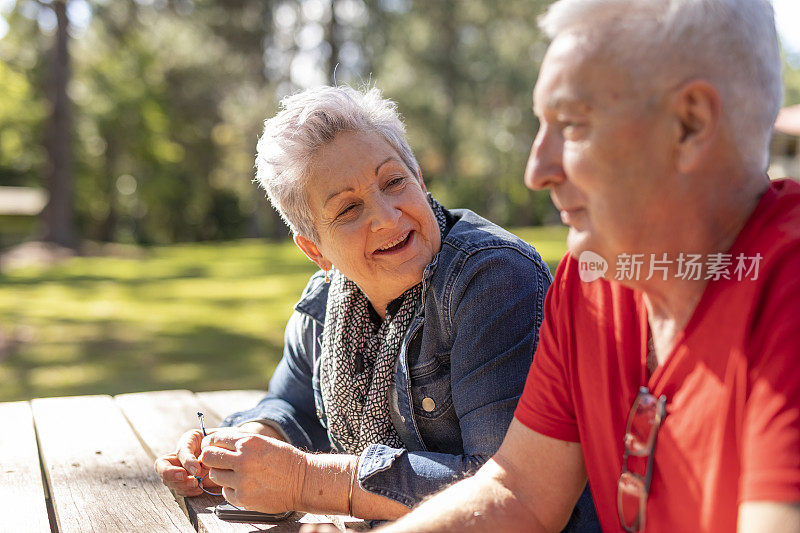 坐在公园长椅上的快乐老年夫妇