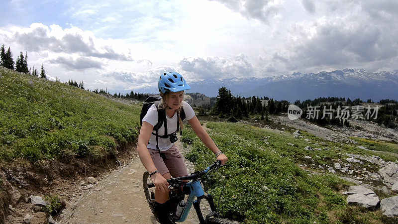 女性山地自行车骑上高山小径