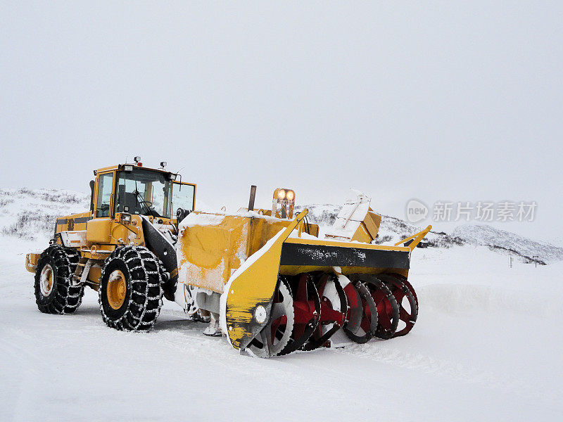 挪威，挖掘机铲雪车在雪道上工作。