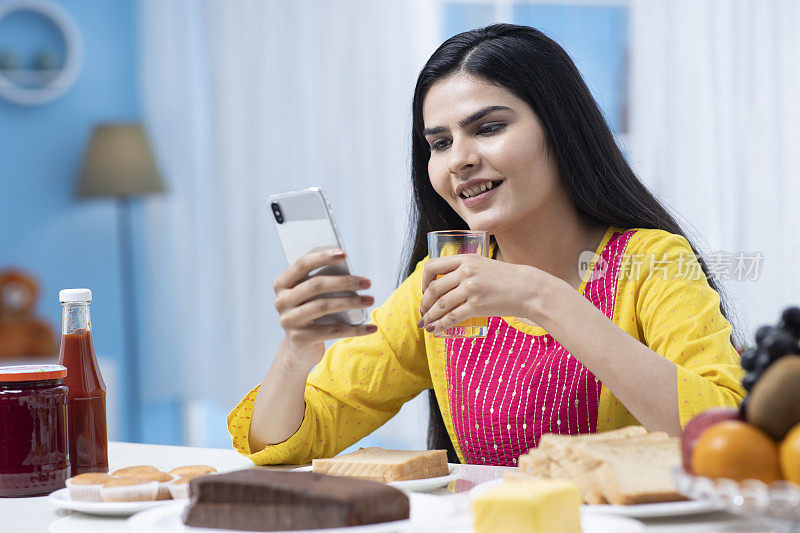 印度妇女在家里吃早餐库存照片