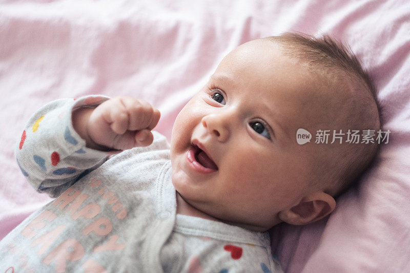 微笑的孩子。三个月的小女孩玩着笑着。COVID-19大流行期间的新生儿。