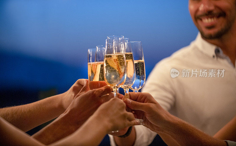 一群朋友在晚上用香槟举杯。