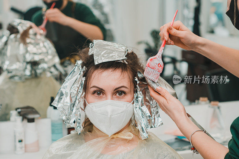 一个女人在理发店里染发，用箔纸染发。