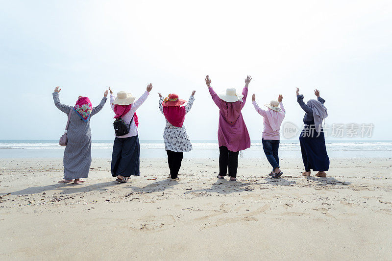 穆斯林妇女在海滩度假期间的周末活动-股票照片
