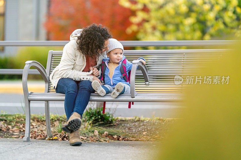 放学后，小女孩和妈妈坐在公园长椅上