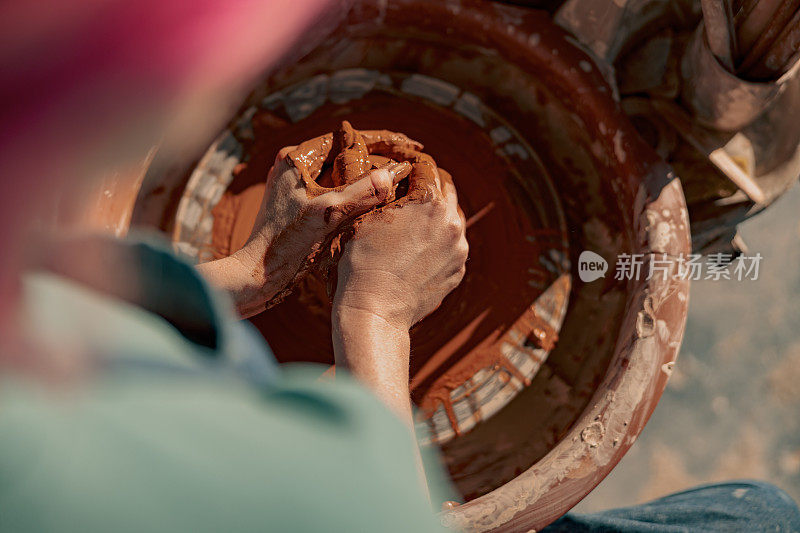 女陶工在工作室的陶轮上塑造粘土