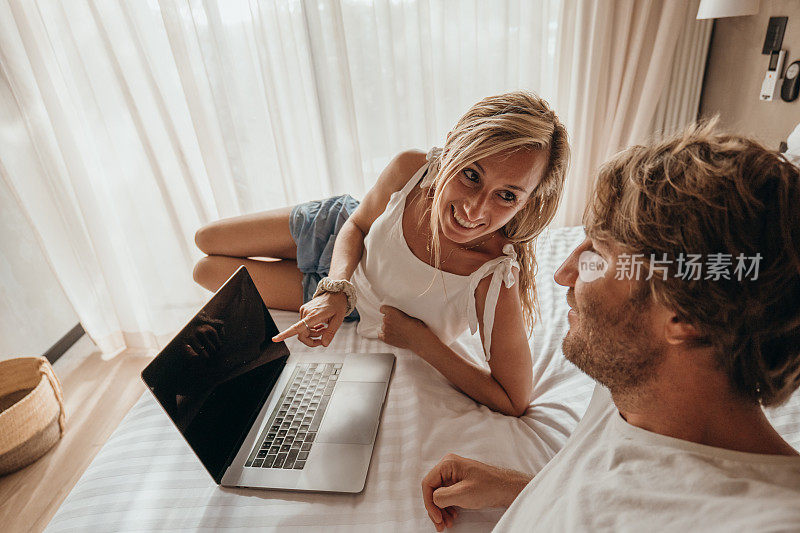 夫妇在卧室里用电脑，晨光