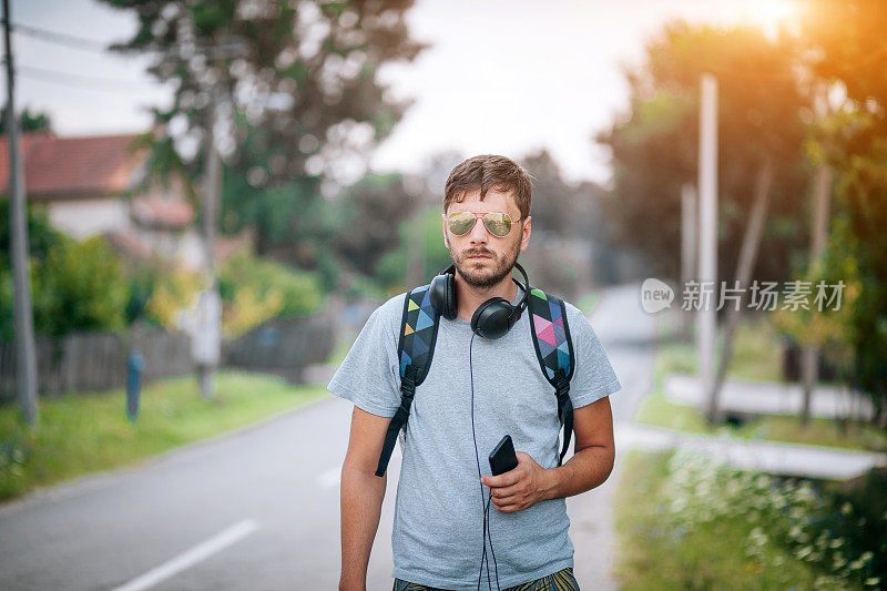 年轻人在户外使用手机和耳机