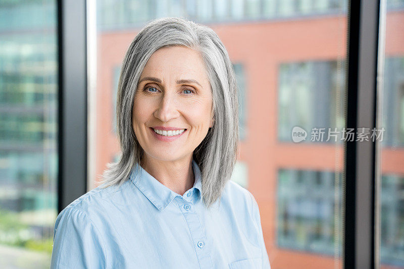 微笑自信的60岁白发成熟女性的肖像。