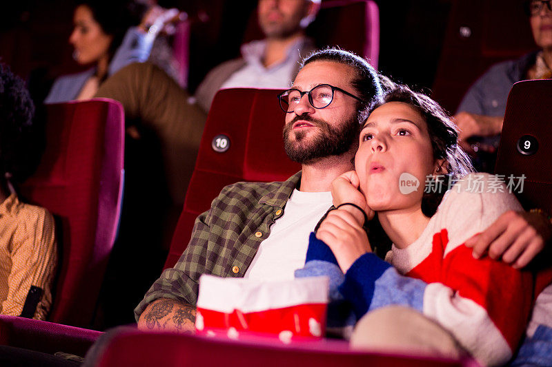 一对年轻夫妇在电影院欣赏浪漫喜剧的肖像