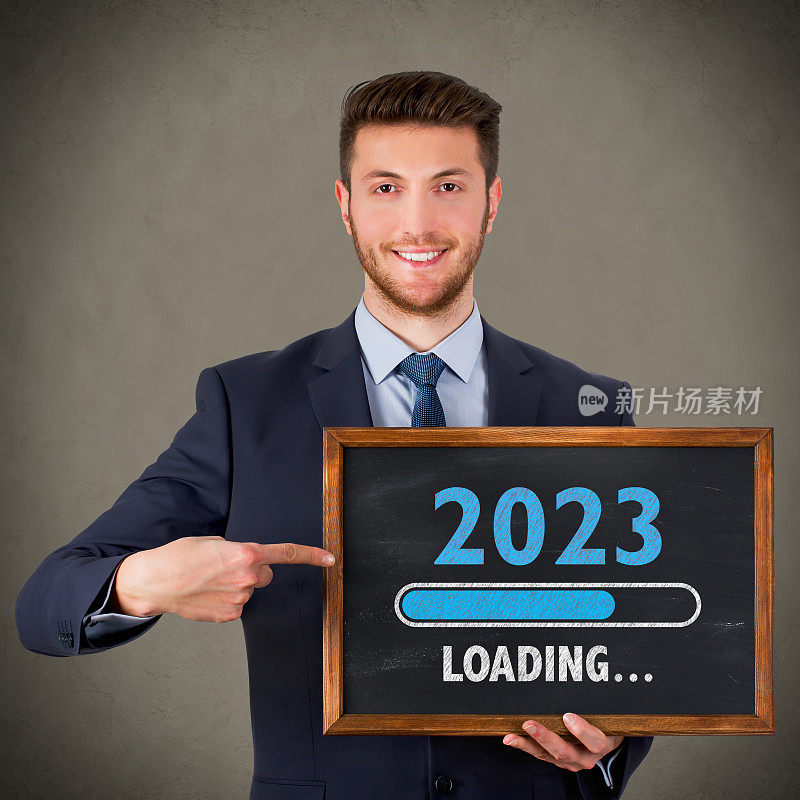 在黑板背景上加载2023年新年的商人绘图