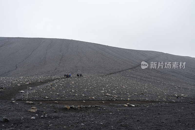 一小群游客徒步登上赫弗贾尔火山