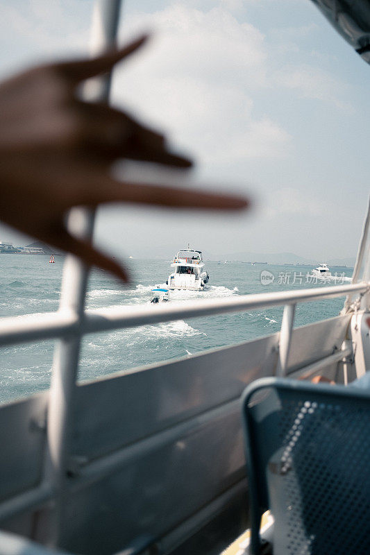 亚洲女孩乘坐渡轮去冒险，享受夏日的微风和景色