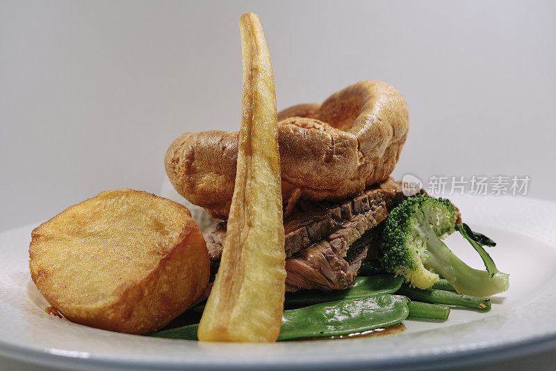 传统的英国周日烤肉，烤牛肉配约克郡布丁，烤土豆和肉汁。