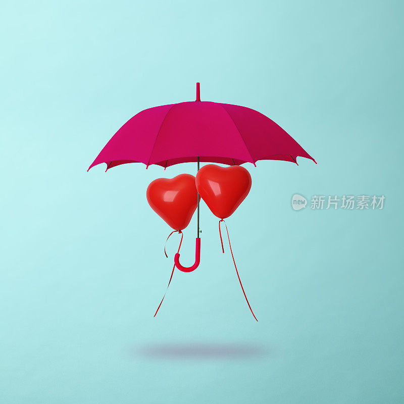 心形的气球共享着粉红色的雨伞漂浮在半空中
