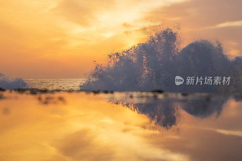 独特的海浪构成，在戏剧性的清晨金色光线反射中创造飞溅图案