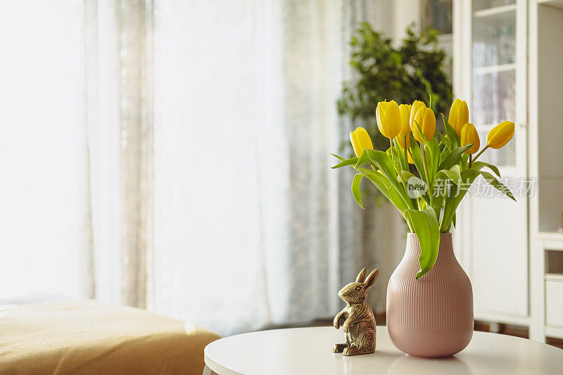 黄色的郁金香插在咖啡桌上的花瓶里。