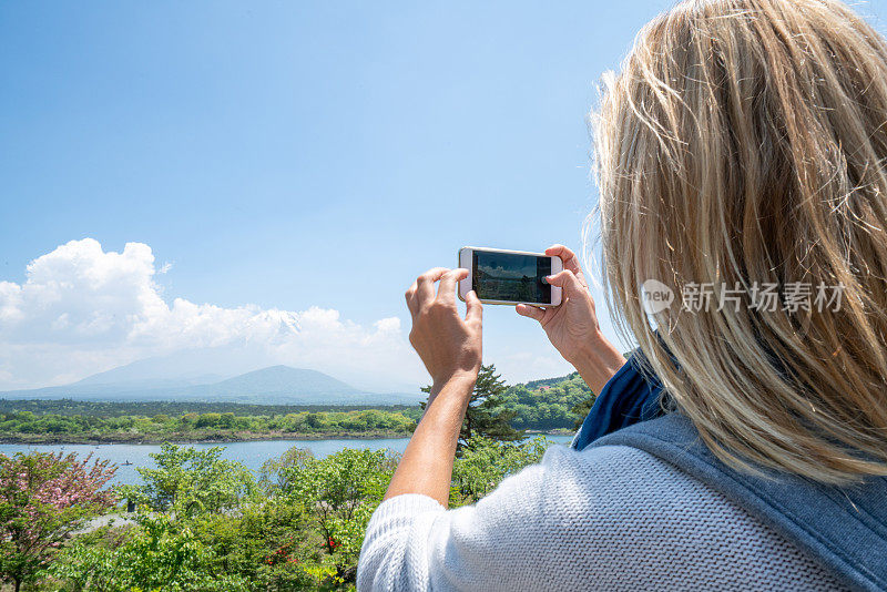 一名女子在日本旅行，她用手机拍了一张照片