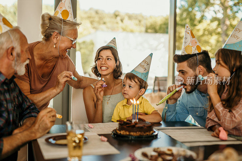 一个小男孩和他的家人在家庆祝他的生日