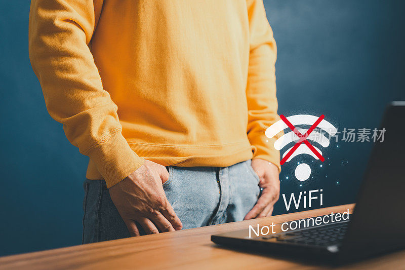 年轻人在家里用笔记本电脑连接wifi但wifi没有连接，并等待加载数字游戏数据表单网站，等待连接wifi的概念技术。