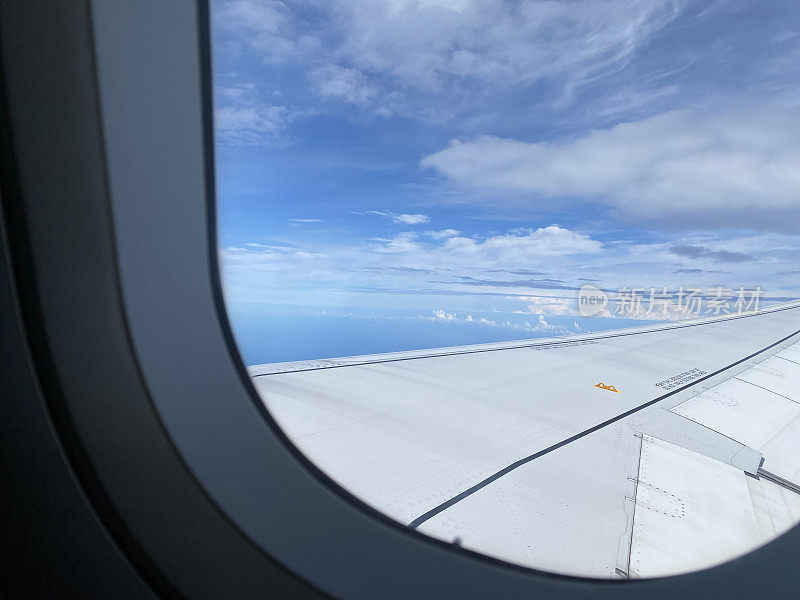 透过窗户看飞机在机翼上飞行，蓝天很漂亮