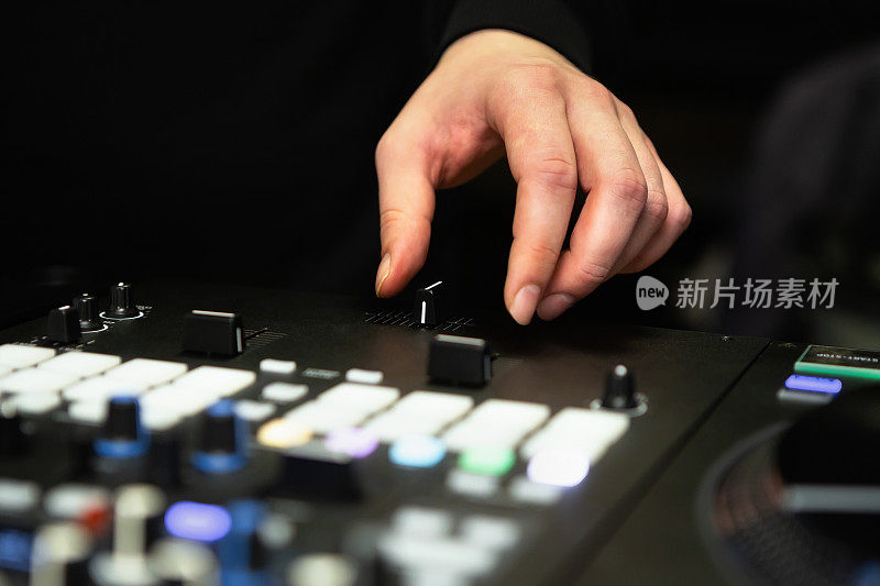 DJ使用混音器上的交叉渐变器在嘻哈派对上刮黑胶唱片