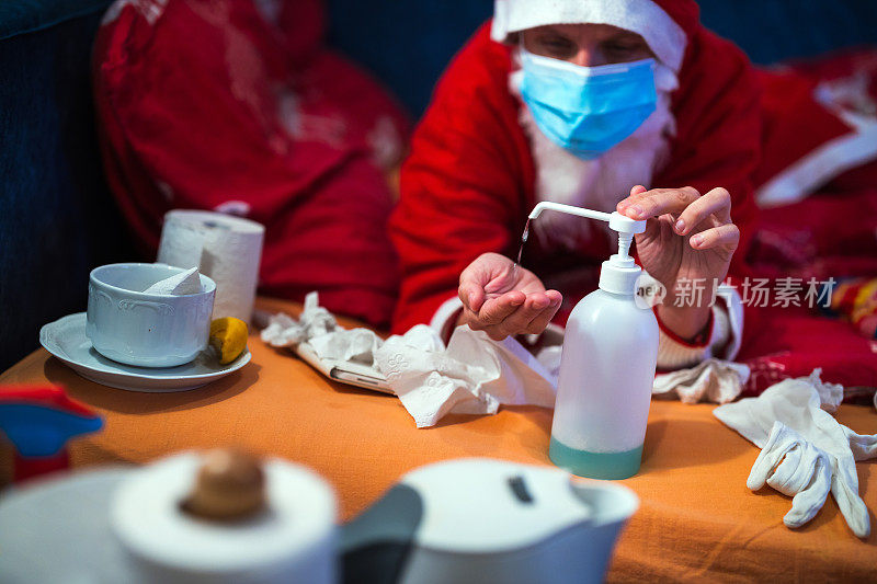 穿着圣诞老人服装的中年成年妇女以圣诞精神在床上与疾病作斗争:节日隔离中的疾病预防
