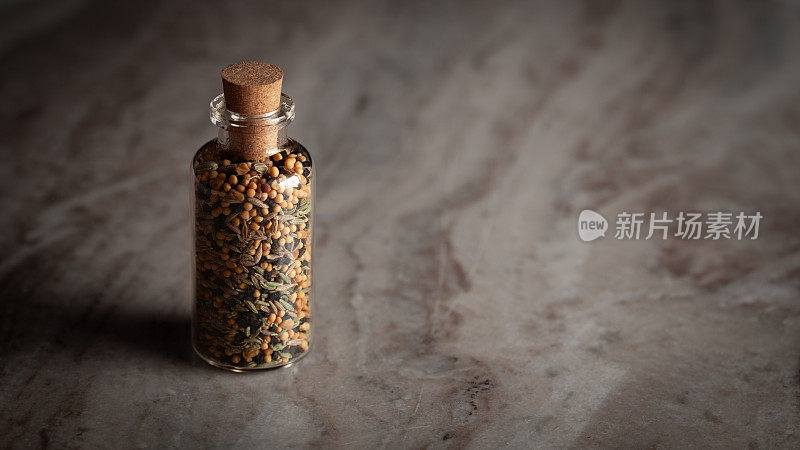 一个小玻璃瓶，里面装满了五种香料的混合物，叫做“Pachphoran”。