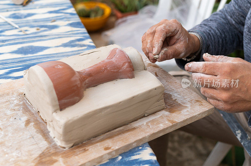 妇女的手正在塑造一个陶瓷模具