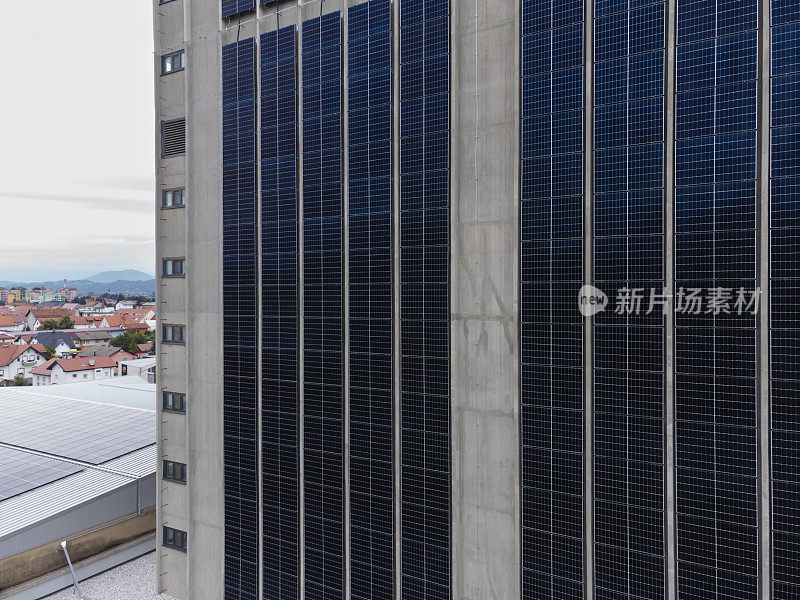 现代建筑立面采用蓝色太阳能电池板，体现城市可再生能源理念。