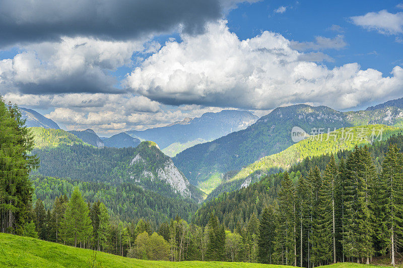 阿尔卑斯山谷，有雪山和春天多云的天空